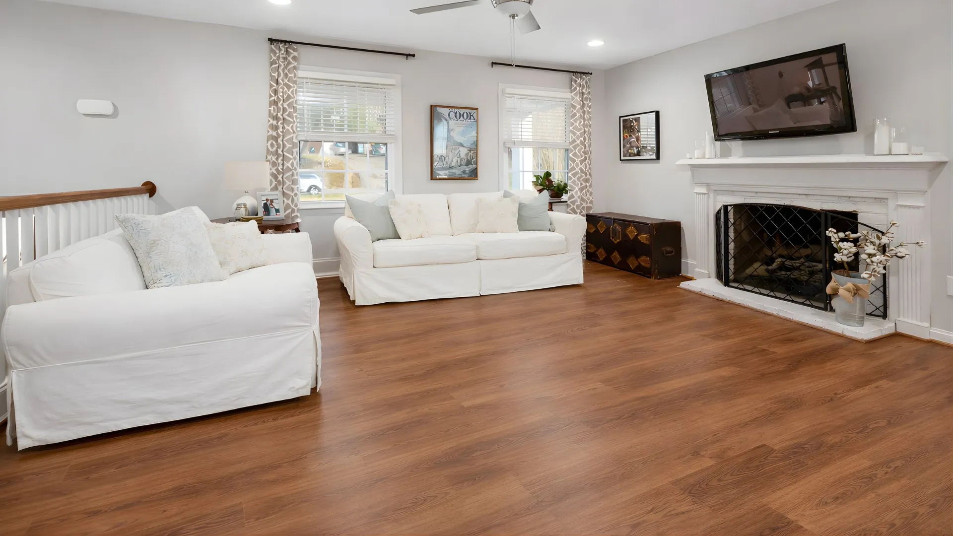 Modern living room with warm oak laminate flooring in Adelaide, showcasing a clean, seamless wood-look finish.