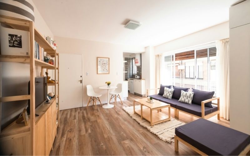 Bright Melbourne living room with timber floors, a wooden bookshelf, and natural light filling the space.