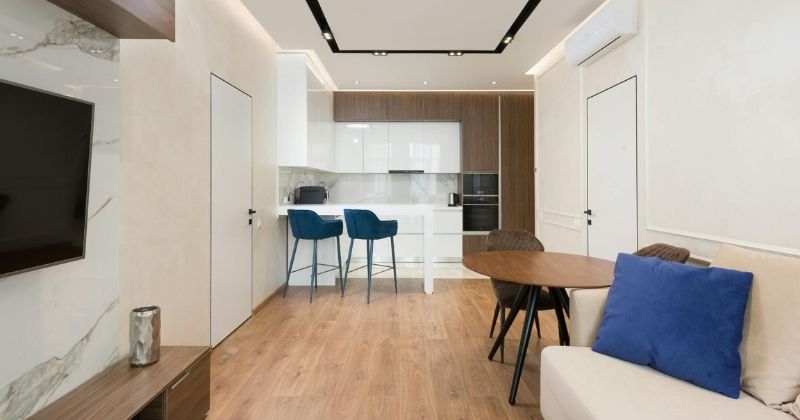Timber flooring installation in a modern open-plan living and kitchen area, featuring natural timber boards, contemporary furniture, and a clean minimalist interior.