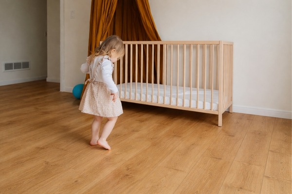 Warm oak laminate flooring in a modern bedroom, showcasing durable wood-look laminate floor installation.